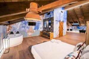 a bedroom with a bed and a tub and a sink at HOTEL SOMNIFABRIK in Valderrobres