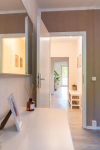 a living room with a table and a hallway at Stylisches Apartment mit Balkon / Netflix / WIFI in Chemnitz