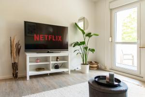 โทรทัศน์และ/หรือระบบความบันเทิงของ Stylisches Apartment mit Balkon / Netflix / WIFI