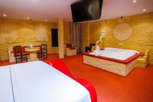 a bedroom with two beds and a tv on the wall at Motel Venus Valladolid in Villanubla