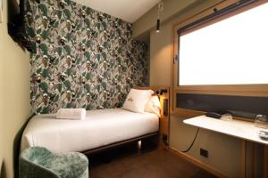 a small room with a bed and a window at Hotel Atari in Donostia-San Sebastián