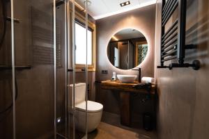 a bathroom with a toilet and a sink and a mirror at Hotel Atari in Donostia-San Sebastián