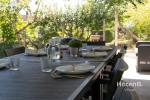 a wooden table with plates and napkins on it at Large house close to city center Limoges in Limoges