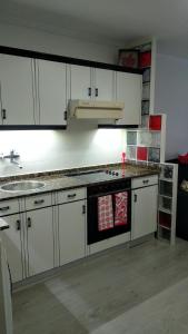 una cucina con mobili bianchi e un forno a piano cottura di Oviedo Centro a Oviedo