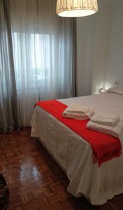 una camera da letto con un letto con una coperta rossa di Oviedo Centro a Oviedo