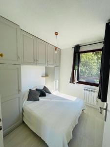 um quarto com uma grande cama branca e uma janela em F2 près débarcadère, en centre ville, des thermes EVIAN LES BAINS 2 étoiles em Évian-les-Bains