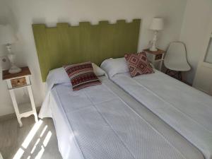 a bedroom with two beds and two tables and a chair at Ave Maria 8 in Tarifa
