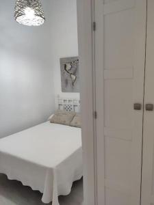 a white bedroom with a bed and white cabinets at Ave Maria 8 in Tarifa