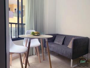 - un salon avec une table et un canapé dans l'établissement The Cozy Studio Los Cristianos, à Los Cristianos