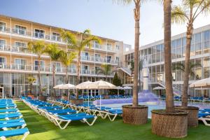 un hotel con piscina, tumbonas y palmeras en htop Platja Park #htopFun, en Platja d'Aro