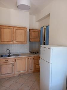 a kitchen with wooden cabinets and a white refrigerator at Il Roseto in Procchio