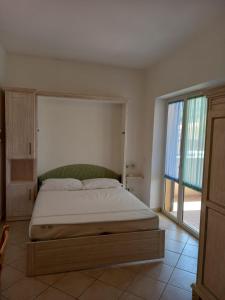 a bed in a bedroom with a large window at Il Roseto in Procchio