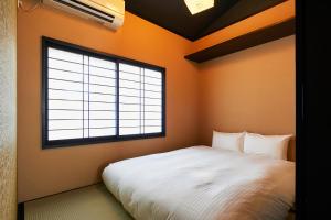 Un dormitorio con una cama blanca y una ventana grande. en TSUBOMI luxury Inn Shimabara Bettei 3, en Kioto 20 fotos más
