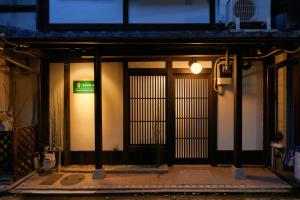 Una entrada a un edificio con un cartel verde. en TSUBOMI luxury Inn Shimabara Bettei 3, en Kioto