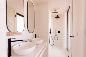 a white bathroom with two sinks and a mirror at Pacha Hotel in Ibiza Town