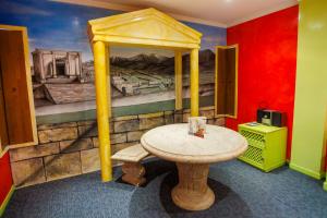 a table in a room with a painting of a bed at Motel Venus Valladolid in Villanubla +97 photos