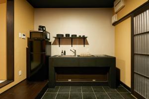 eine Küche mit einer Spüle und einem Kühlschrank in der Unterkunft TSUBOMI luxury Inn Shimabara Bettei 2 in Kyoto