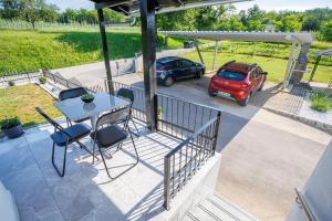 a patio with a table and a car parked on it at Apartment Izvir Lahinje in Dragatuš