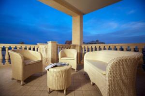 a patio with wicker chairs and tables on a balcony at Hotel Boracay in Alba Adriatica
