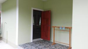 Zimmer mit einer roten Tür und einem Tisch in der Unterkunft Ban Khan LeeMa in Sam Roi Yot