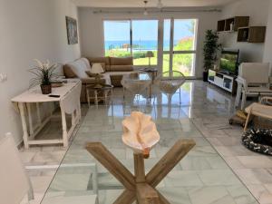 sala de estar con sofá y mesa en Villa Mar Fuente del Sol, en Conil de la Frontera