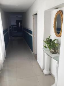 a hallway with a white tile floor and a mirror at Aparthotel Continental in San Miguel de Tucumán