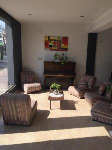 a living room with couches and a piano at Aparthotel Continental in San Miguel de Tucumán