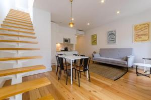 a living room with a staircase and a table and chairs at Light House Apartments - Casas da Baixa in Lisbon