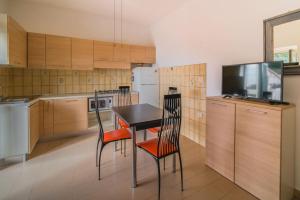 uma cozinha com uma mesa e cadeiras e uma televisão em La Terrazza a Seccheto Sul Mare em Seccheto
