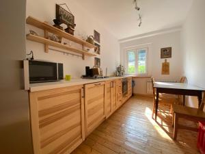 a kitchen with wooden cabinets and a television and a table at Chybotek Premium in Przesieka