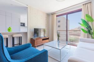 ein Wohnzimmer mit einem blauen Sofa und einem Glastisch in der Unterkunft The Terraces Luxury Penthouses, 3D in Santa Cruz de Tenerife