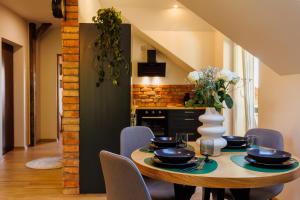 a dining room with a wooden table and chairs at Stylowe apartamenty in Charzykowy