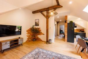 ein Wohnzimmer mit Flachbildfernseher und Tisch in der Unterkunft Stylowe apartamenty in Charzykowy