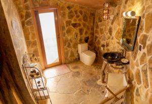 a stone bathroom with a toilet and a sink at Souly Ecolodge Salalah in Salalah