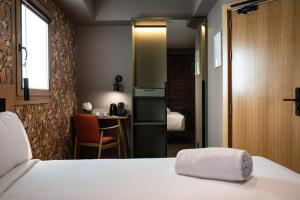 a bedroom with a bed and a table in a room at Hotel Atari in Donostia-San Sebastián