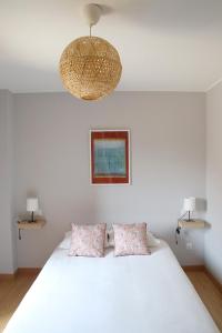 波德利亞內斯的住宿－CASA TORANDA con JARDIN EN POO DE LLANES，卧室配有一张带两个枕头的大白色床