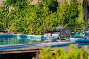 a chair sitting next to a swimming pool at Pestana Troia Eco-Resort & Residences in Troia