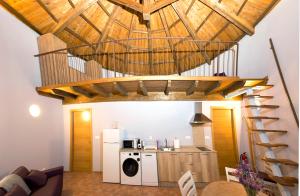 eine Küche mit einer Waschmaschine und einem Trockner unter einer Holzdecke in der Unterkunft Pallozas Turísticas Ridicodias - A Vieira in Laza