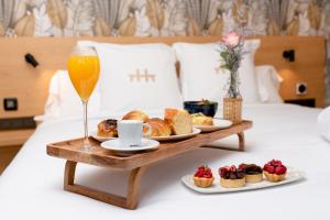 a tray of food and a glass of wine on a bed at Hotel Atari in San Sebastián