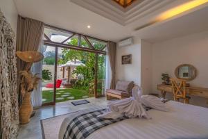 ein Schlafzimmer mit einem Bett und einem großen Fenster in der Unterkunft Miracle villa Canggu in Canggu