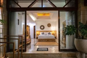 ein Schlafzimmer mit einem Bett in einem Zimmer mit Glastüren in der Unterkunft Miracle villa Canggu in Canggu