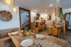 eine Küche und ein Esszimmer mit einem Holztisch in der Unterkunft Miracle villa Canggu in Canggu