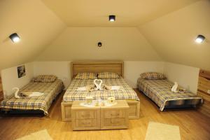 Schlafzimmer im Dachgeschoss mit 2 Betten und einem Tisch in der Unterkunft Vila Carobni Kutak in Rudno