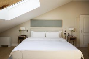 um quarto com uma cama branca e duas mesas de cabeceira em Château de Montcaud em Sabran