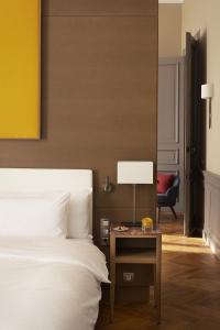 um quarto com uma cama e uma mesa com um candeeiro em Château de Montcaud em Sabran