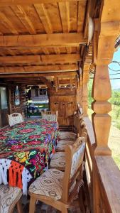 a bedroom in a log cabin with a bed and chairs at Pensiunea Teodora Breb Maramu in Breb