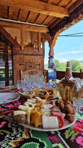 una mesa con un plato de comida y una botella en Pensiunea Teodora Breb Maramu en Breb