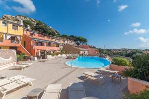 un resort con piscina, sedie e edifici di C 102 Puntavilla Mare a La Maddalena