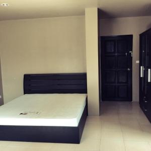 a bedroom with a bed and a black door at The State Apartment in Bangkok