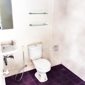 a bathroom with a toilet and a sink at The State Apartment in Bangkok